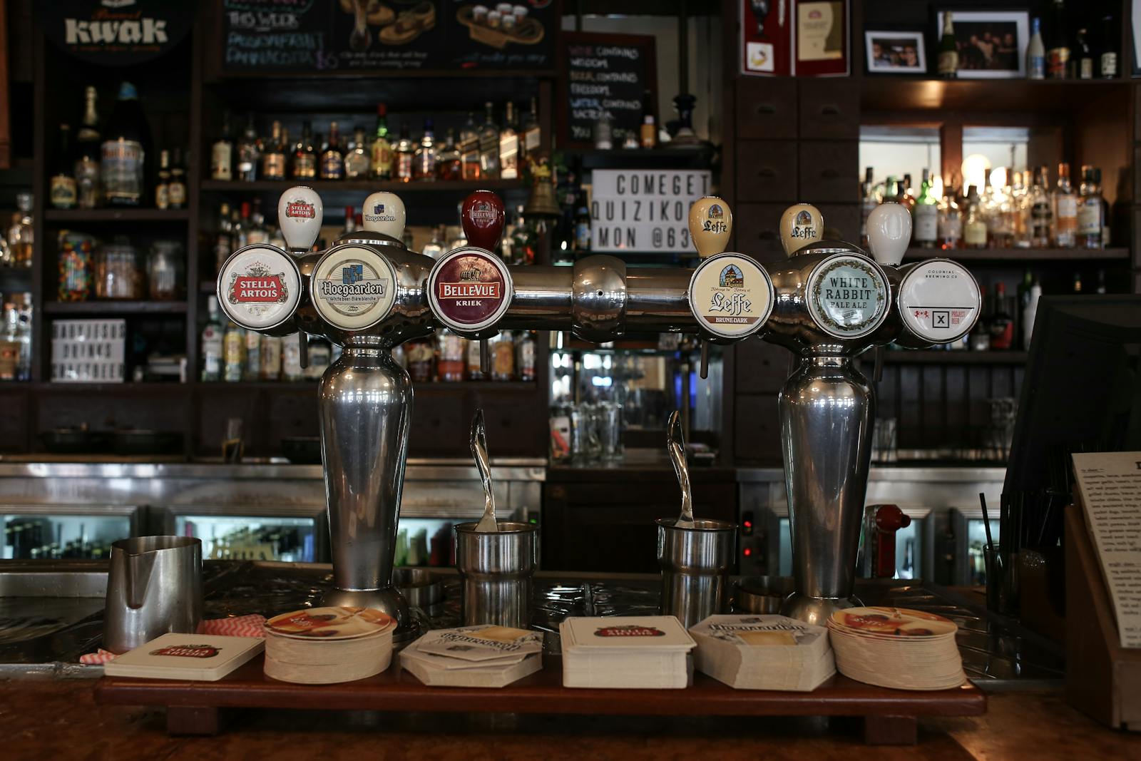 Draft beer tap handles showing different keg coupler connections at a bar